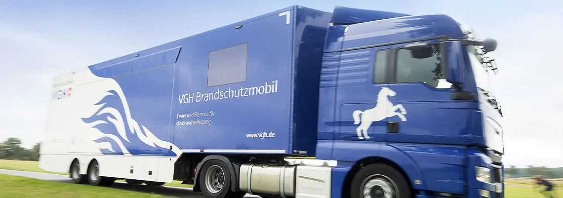 Bild zeigt das Zugfahrzeug und den Spezialbau des Aufliegers der VGH Brandschutzversicherung z.B. zu Beratungszwecken