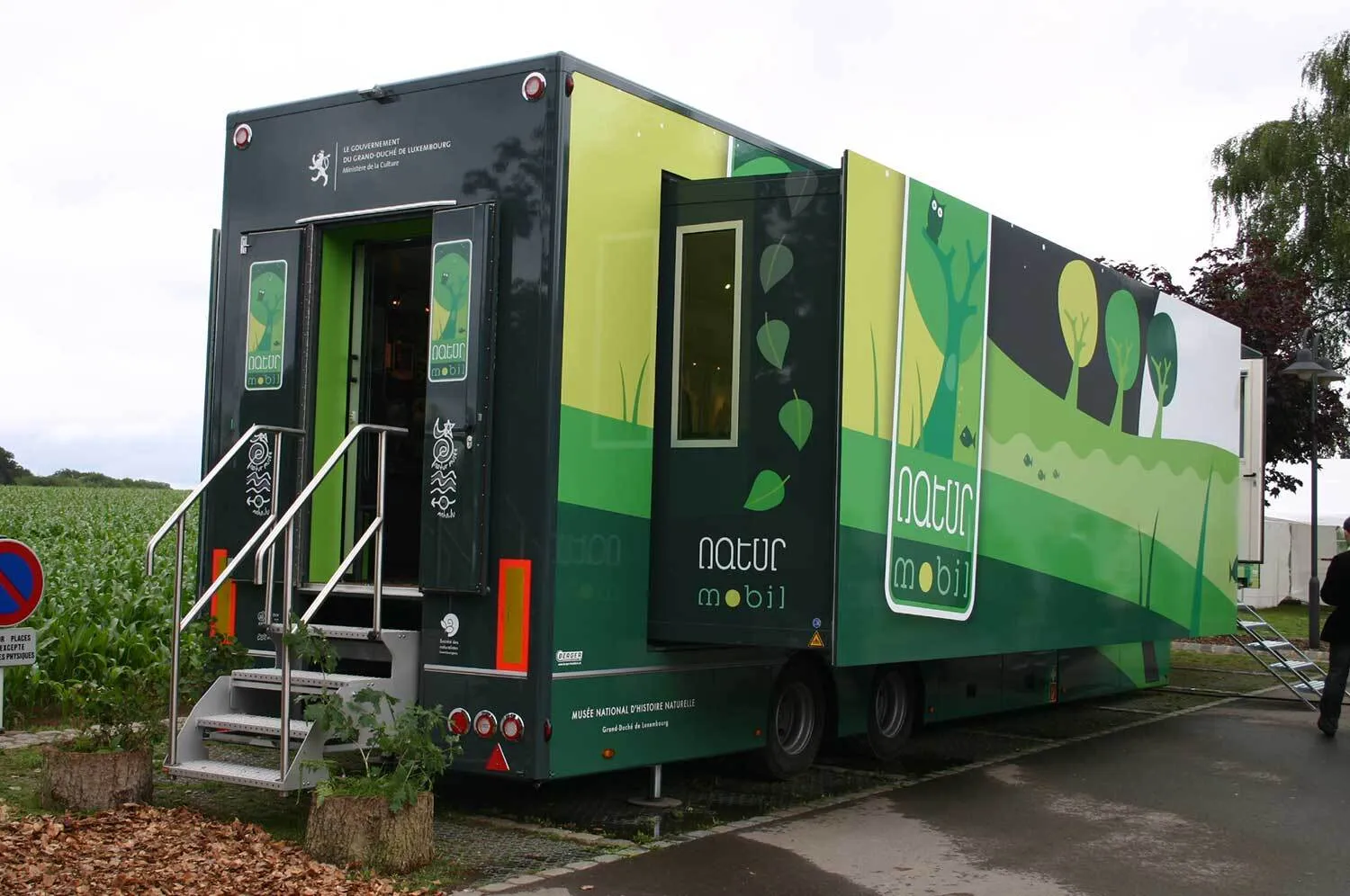 Darstellung eines großen Anhangers mit schrägen Zugang im Heckbereich und ausfahrbaren Seitenteilen, zur Raumvergrößerung