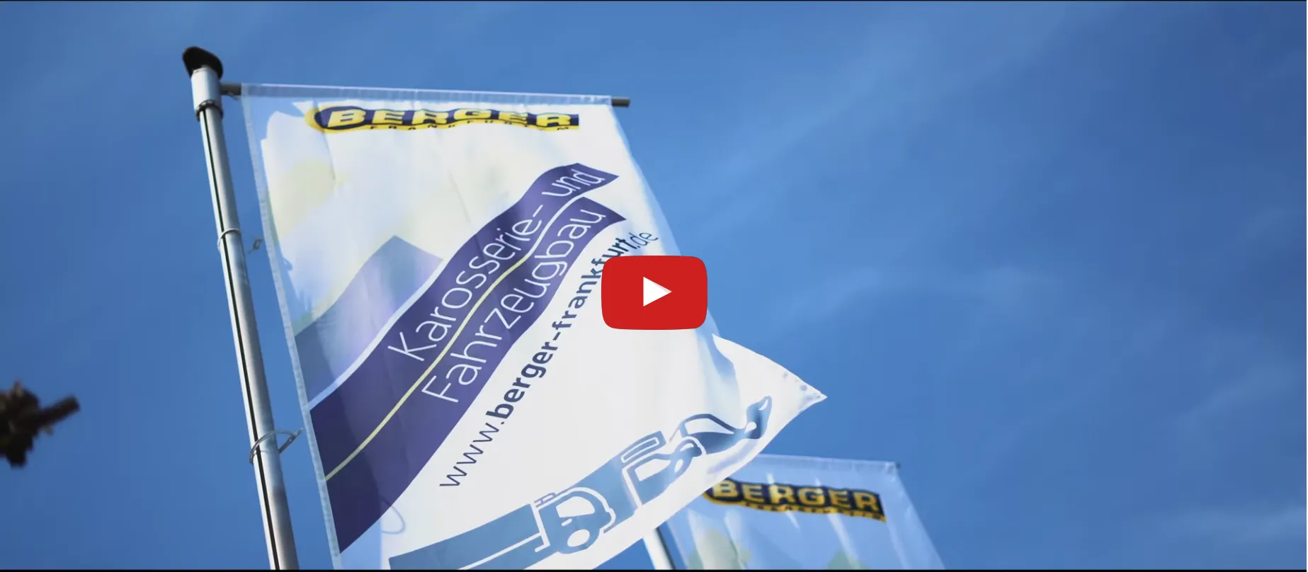 Bild zeigt eine wehende Berger Karosserie- und Fahrzeugbau Fahne. Bei einem Klick auf das Bild wird das Imagevideo auf Youtube von Berger gezeigt